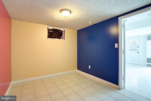 tiled empty room with visible vents and baseboards