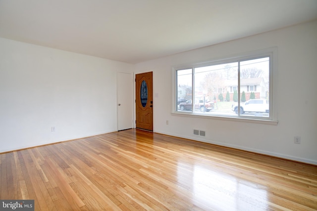 spare room with visible vents, light wood-style flooring, and baseboards