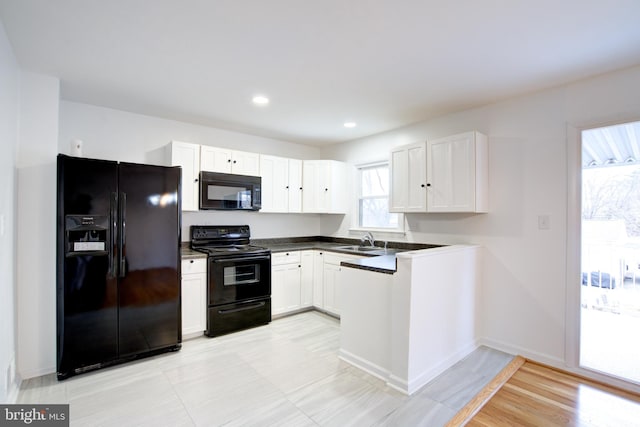 kitchen with recessed lighting, a sink, black appliances, white cabinetry, and dark countertops