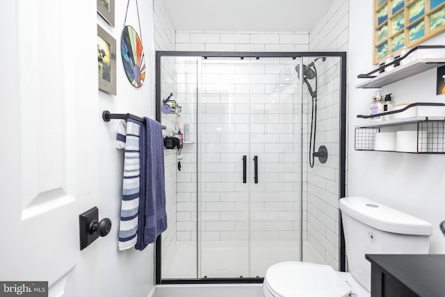 full bath with a stall shower, vanity, and toilet