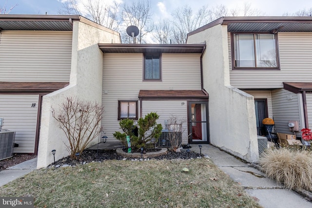 rear view of house featuring central AC unit and stucco siding