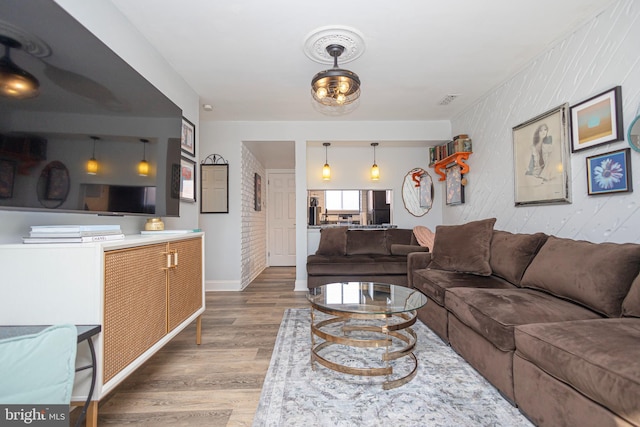 living room featuring baseboards, visible vents, and wood finished floors