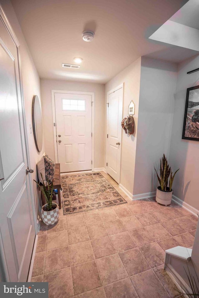 foyer entrance featuring baseboards and visible vents