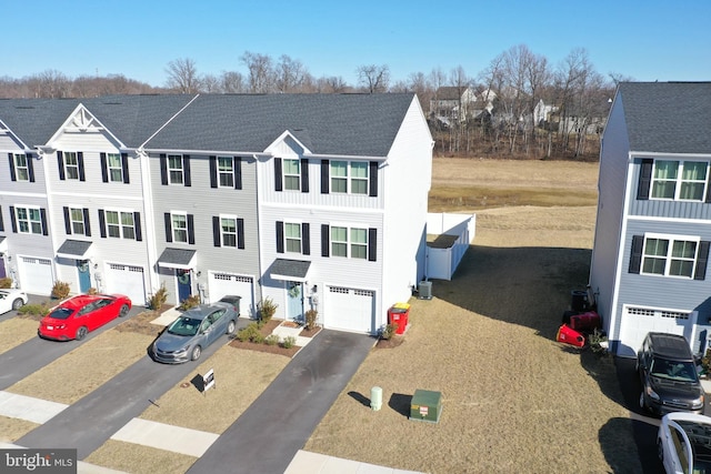 townhome / multi-family property with central AC unit, a garage, and driveway