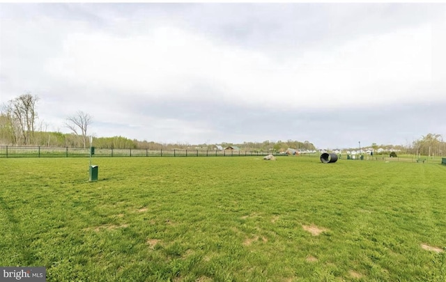 view of yard with a rural view and fence