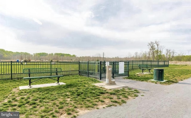 view of home's community with a yard, a rural view, and fence