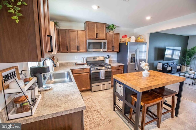 kitchen with a sink, light countertops, recessed lighting, and stainless steel appliances