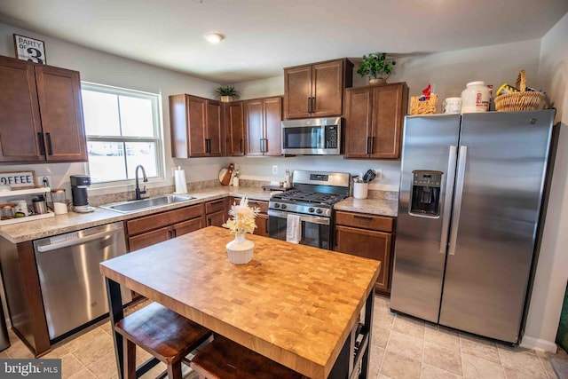 kitchen featuring a sink, dark brown cabinets, appliances with stainless steel finishes, and light countertops