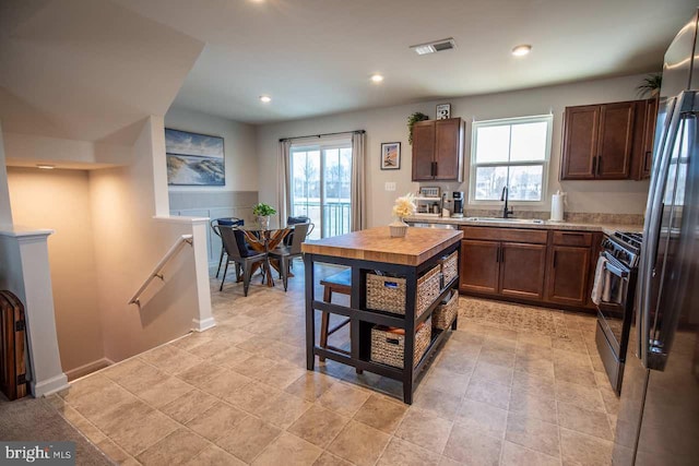 kitchen featuring a sink, range with gas cooktop, visible vents, and a healthy amount of sunlight