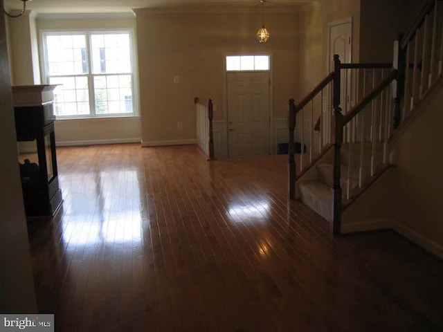 entrance foyer with wood-type flooring, a fireplace, stairway, and baseboards