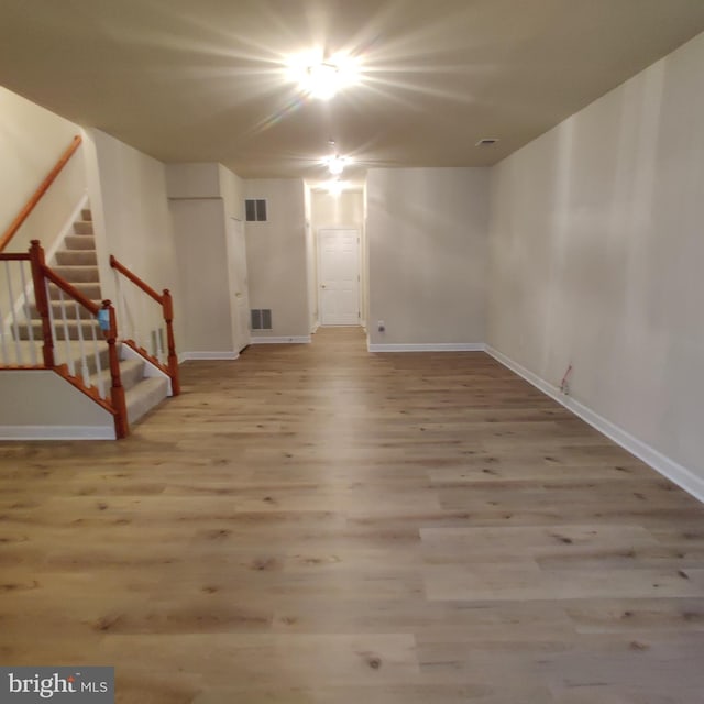 interior space featuring visible vents, stairway, baseboards, and wood finished floors