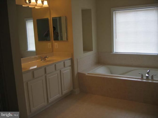 bathroom featuring tile patterned floors, vanity, and a bath