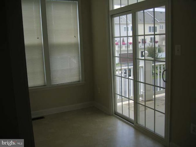 doorway with plenty of natural light, visible vents, and baseboards