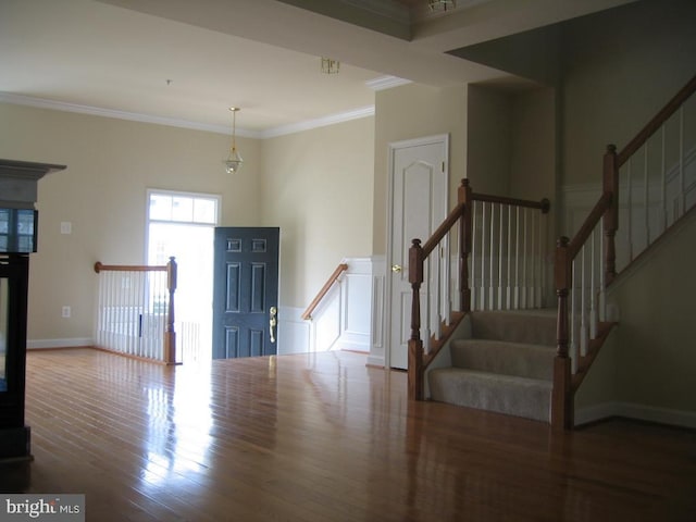 foyer with baseboards, wood finished floors, and crown molding