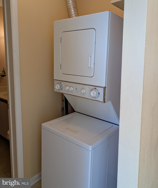 clothes washing area with laundry area and stacked washer and clothes dryer