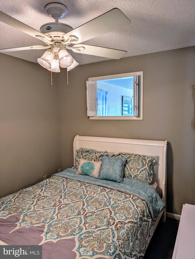 bedroom featuring ceiling fan and a textured ceiling