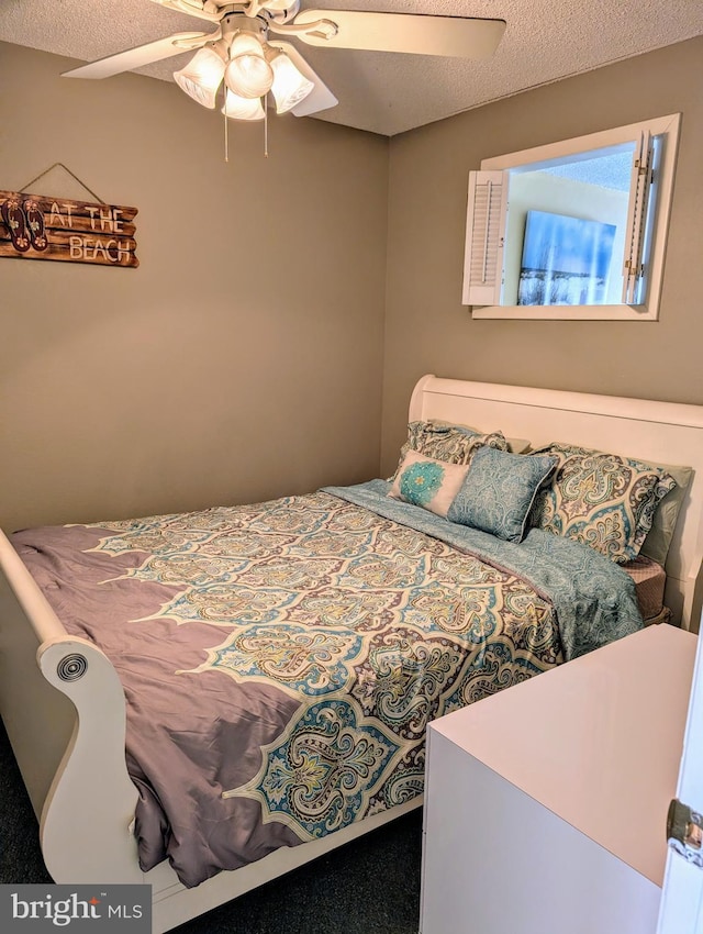 bedroom with a textured ceiling and a ceiling fan