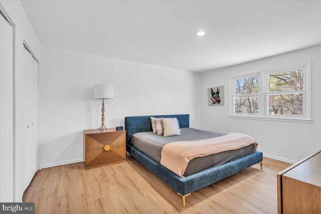 bedroom featuring recessed lighting, wood finished floors, baseboards, and a closet