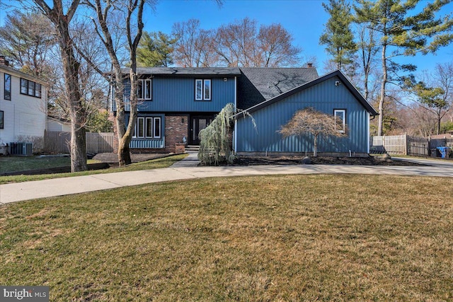 view of front of property with brick siding, a front lawn, fence, concrete driveway, and cooling unit