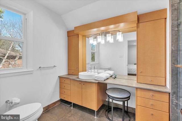 ensuite bathroom featuring toilet, ensuite bathroom, baseboards, vanity, and vaulted ceiling