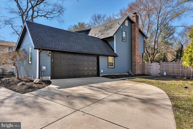 view of side of home with fence, concrete driveway, roof with shingles, a chimney, and a garage