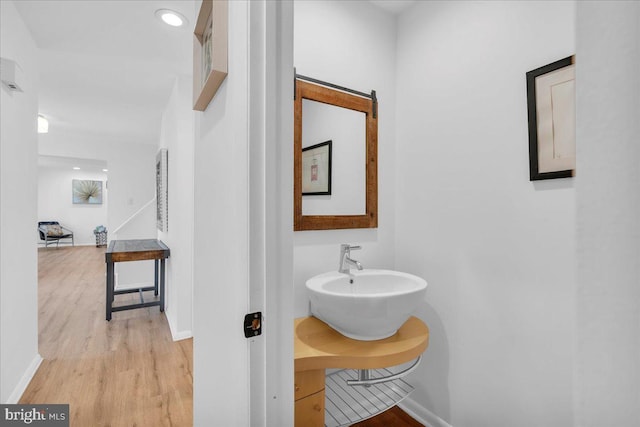 bathroom with a sink, baseboards, and wood finished floors