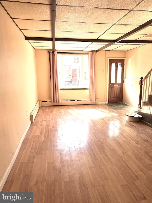 interior space featuring stairway, baseboard heating, wood finished floors, and baseboards