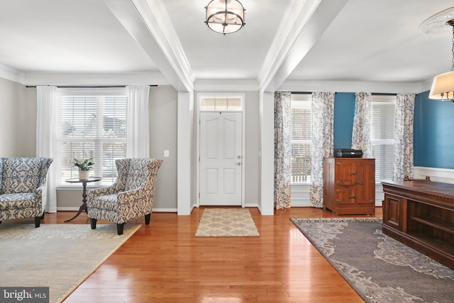 foyer entrance featuring crown molding, baseboards, and wood finished floors