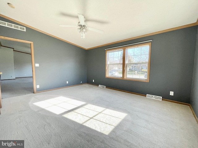 carpeted spare room featuring baseboards, visible vents, and ornamental molding