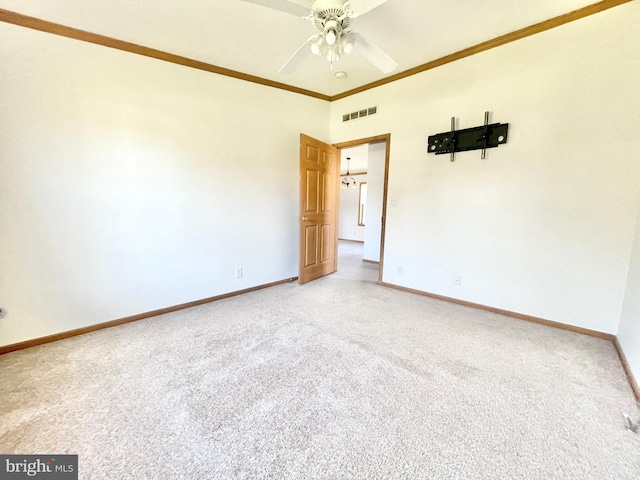 empty room featuring baseboards, visible vents, carpet flooring, and ornamental molding