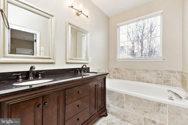 full bathroom with double vanity, a sink, and a bath