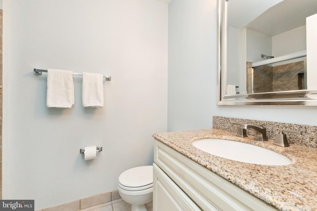 full bathroom featuring toilet, vanity, a tile shower, and tile patterned floors