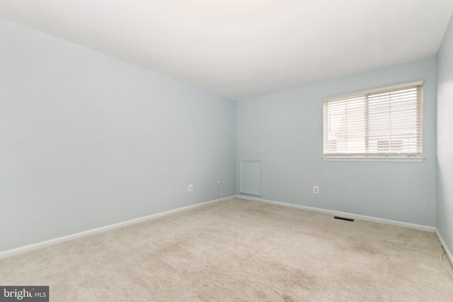 carpeted spare room featuring visible vents and baseboards