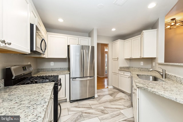 kitchen featuring stainless steel appliances, recessed lighting, white cabinets, and a sink