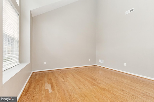 spare room featuring light wood-style floors and baseboards