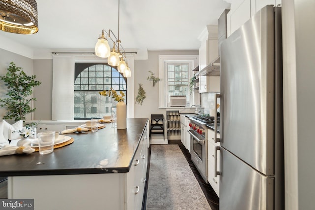 kitchen with freestanding refrigerator, oven, white cabinets, and dark countertops