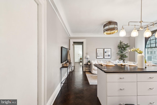 kitchen featuring dark countertops, white cabinetry, and baseboards