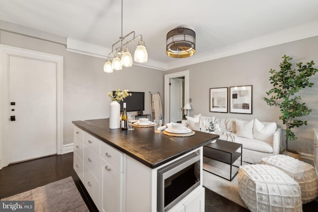 kitchen featuring open floor plan, white cabinetry, dark wood finished floors, and butcher block counters