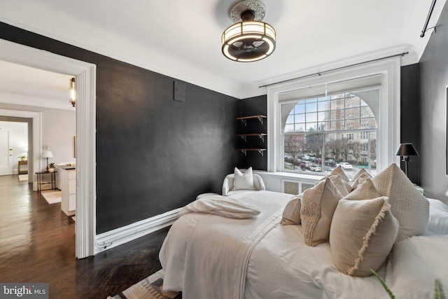 bedroom with wood finished floors and baseboards