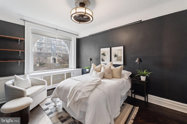 bedroom with wood finished floors and baseboards