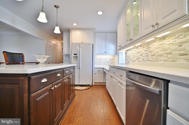 kitchen with dark brown cabinetry, white refrigerator with ice dispenser, white cabinetry, light countertops, and stainless steel dishwasher