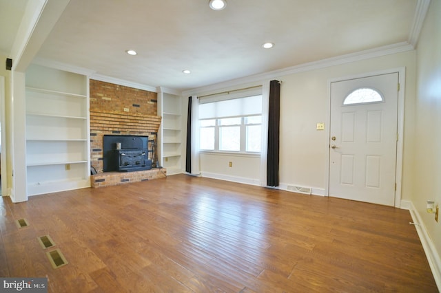 unfurnished living room featuring wood finished floors, visible vents, and a healthy amount of sunlight