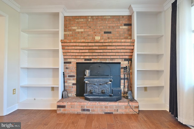 details with ornamental molding, a wood stove, built in features, and wood finished floors