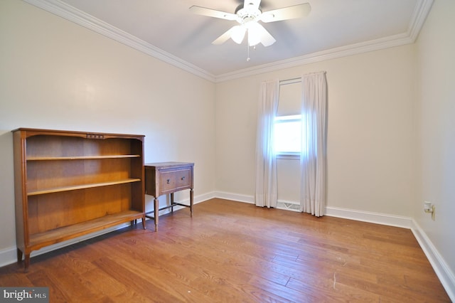 empty room with wood finished floors, visible vents, baseboards, a ceiling fan, and crown molding