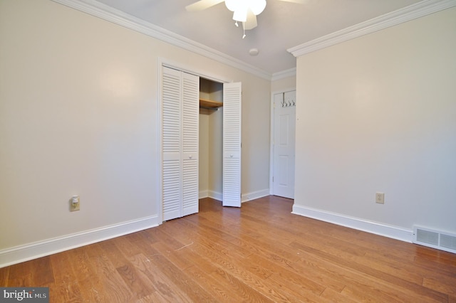 unfurnished bedroom featuring ornamental molding, light wood-type flooring, visible vents, and baseboards