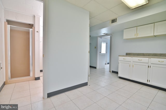 kitchen with light tile patterned floors, visible vents, and white cabinetry