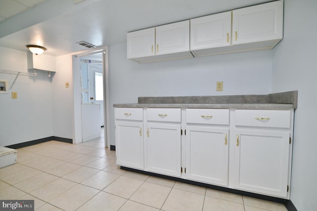 kitchen featuring light tile patterned floors, visible vents, baseboards, and white cabinets