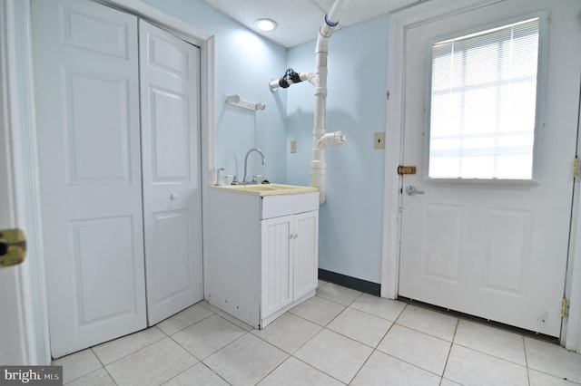 bathroom with tile patterned flooring, baseboards, and vanity