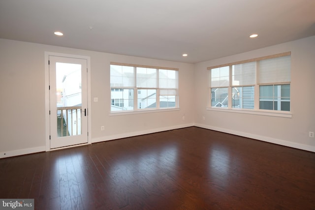 spare room with dark wood-style floors, recessed lighting, and baseboards