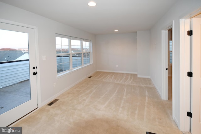 carpeted empty room with baseboards, visible vents, and recessed lighting